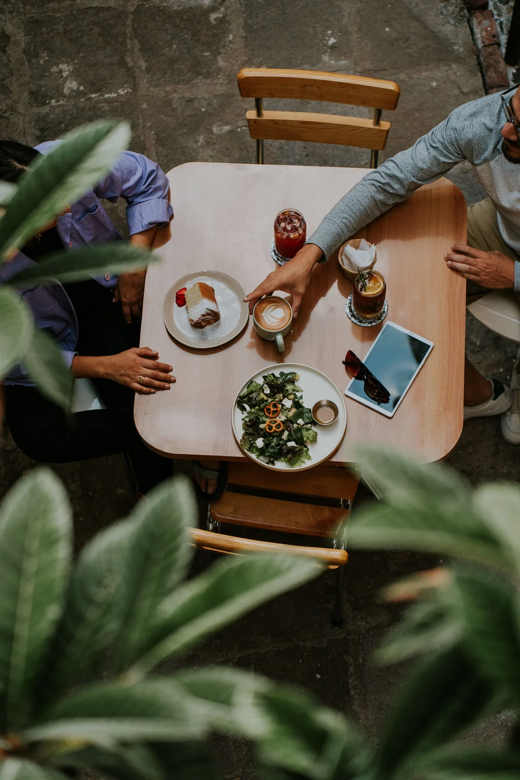 Dos personas compartiendo café y comida en una mesa.