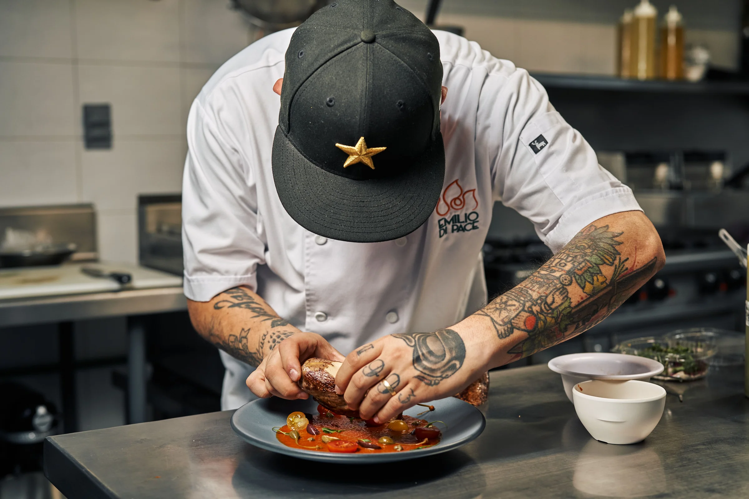 Chef colocando los ingredientes de un plato en una cocina.